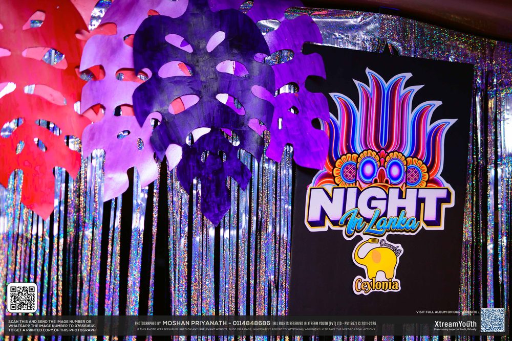 The Night in Lanka backdrop on deck, lotus logo lit up against silver streamers.