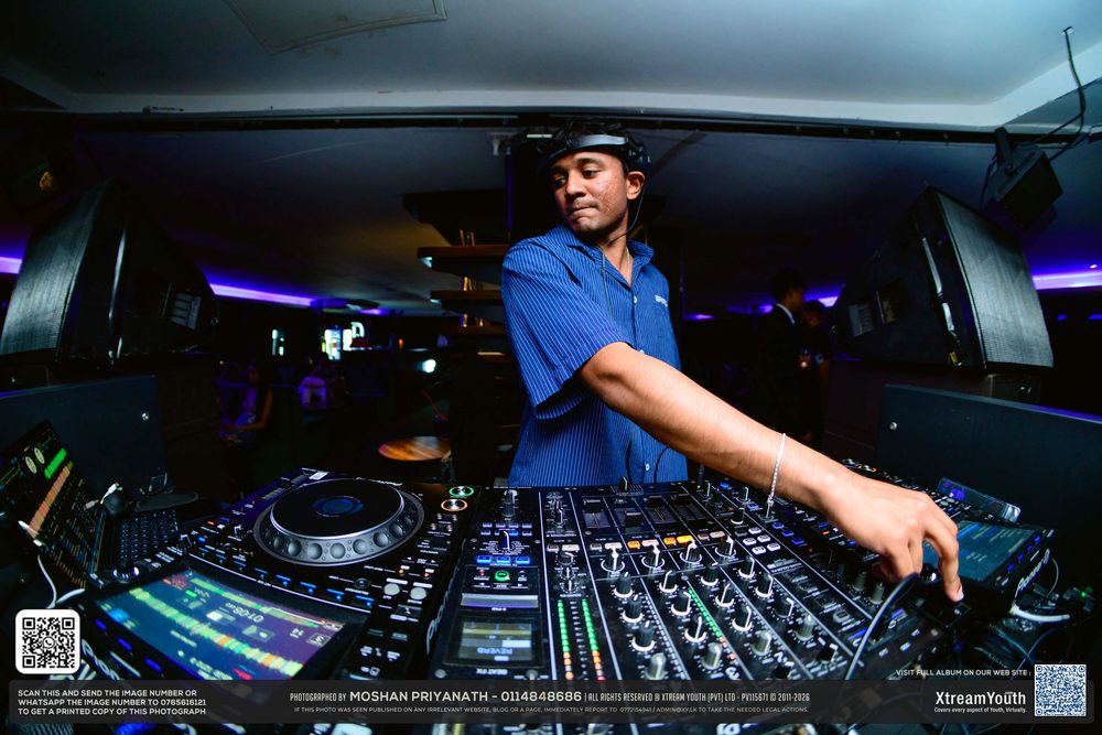 Hands working the CDJs, the lit mixer filling the frame.