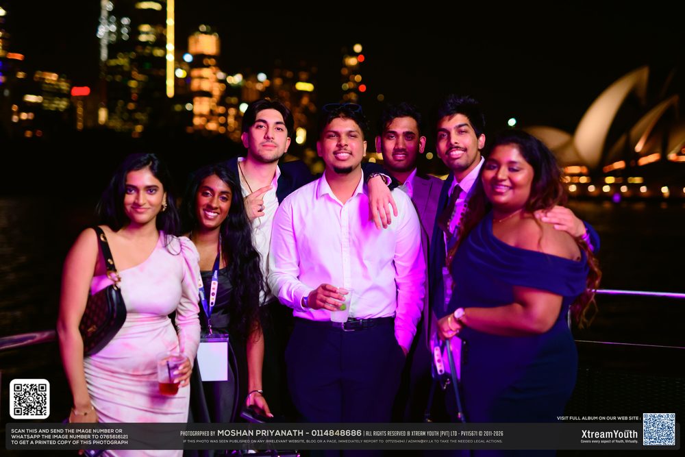 A group on deck with the Opera House sails and the city skyline behind them.