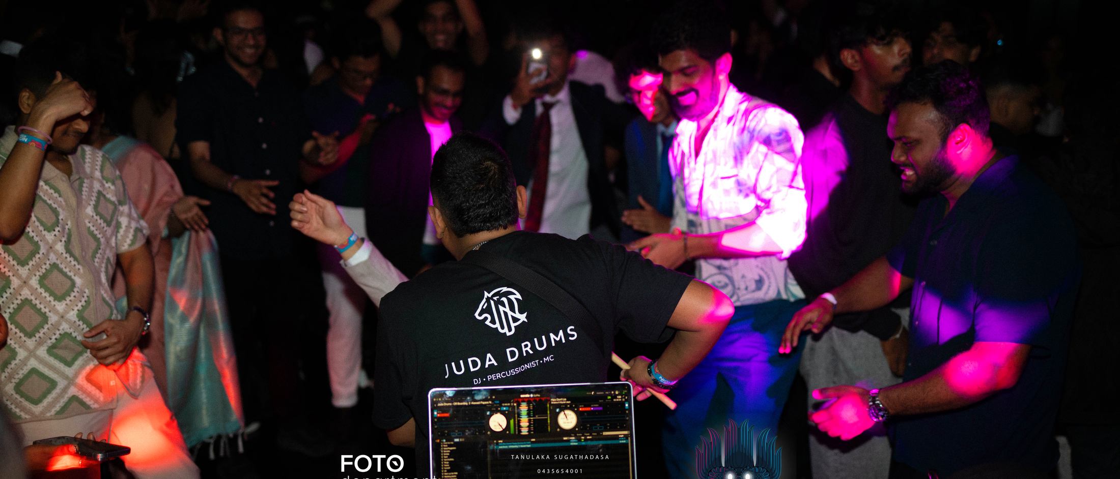 The dance floor packed in front of the DJ booth at Night in Lanka 2025, lit deep magenta.