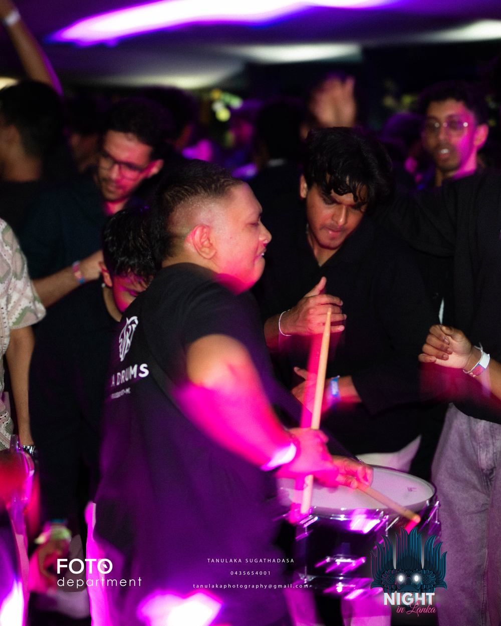 Raban drums being played in the middle of the crowd, hands raised around them.